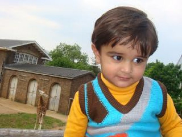 child at the zoo with house at back