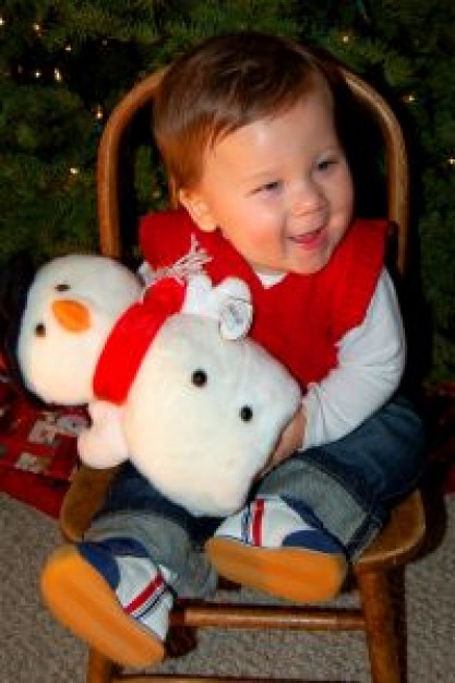 happy boy hang with snowman sitting on the desk