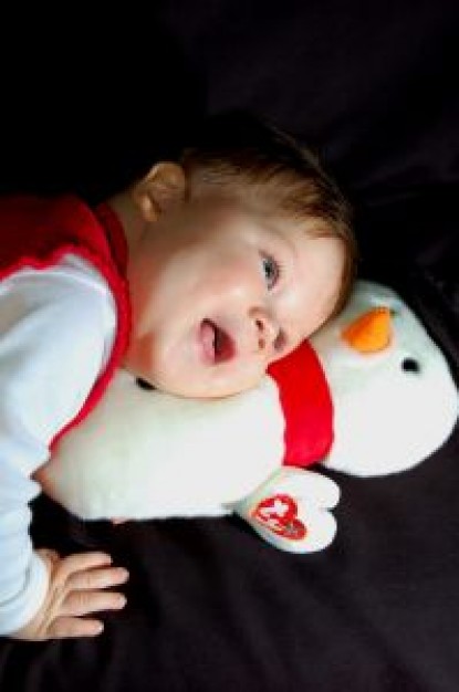 happy boy huging snowman lying on the bed