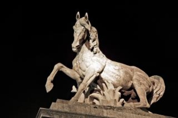 lying stone horse statue with dark background