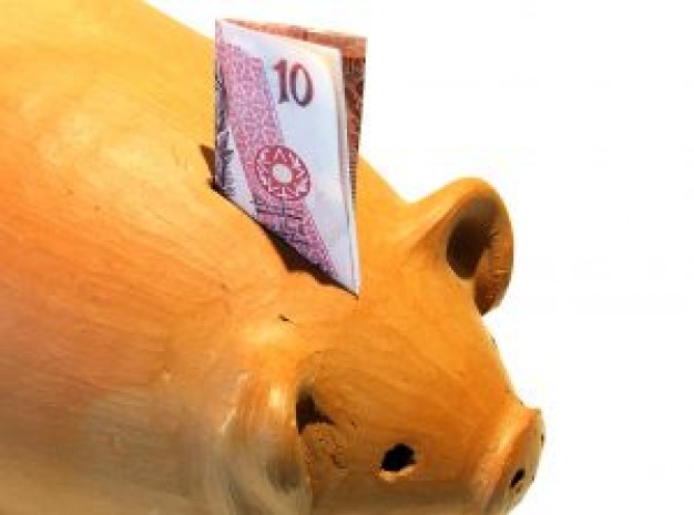 orange piggy bank with paper money on top