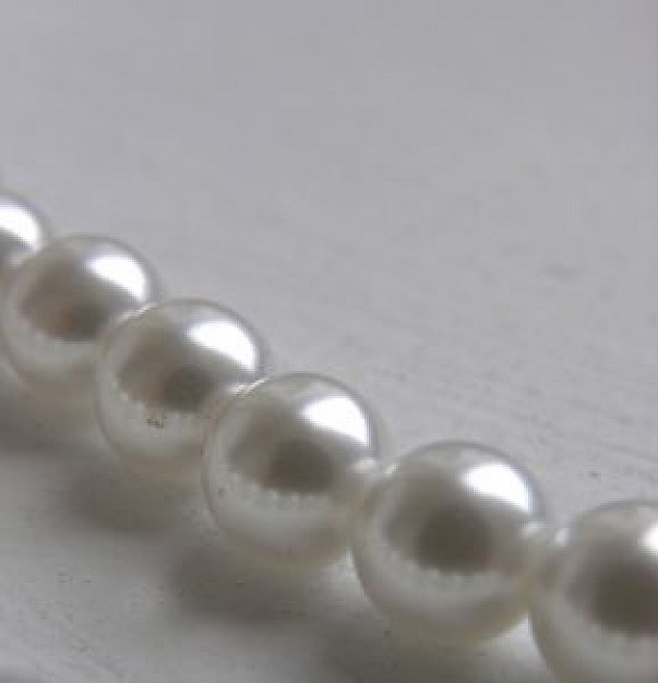 pearls chain lying on white surface