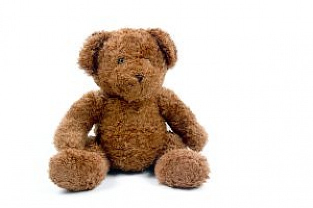 teddy bear sitting at white surface