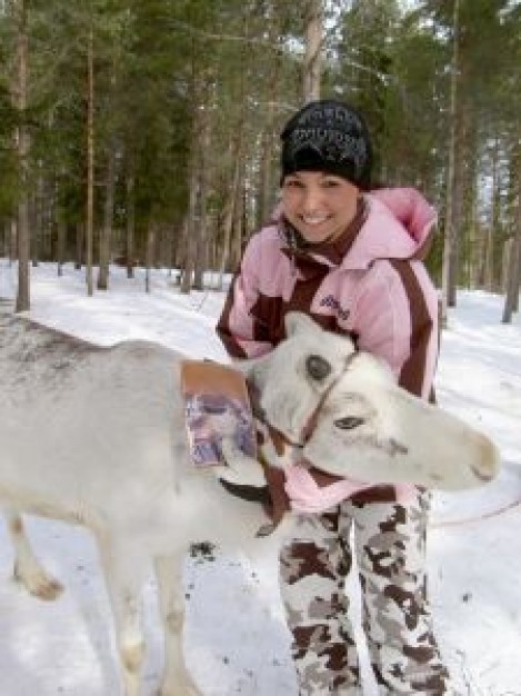 woman hug the reindeer in the snow forest